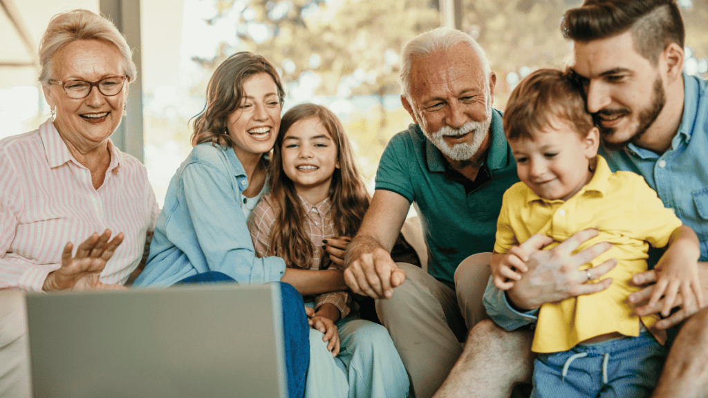 Multigenerational family laughing and looking at a laptop
