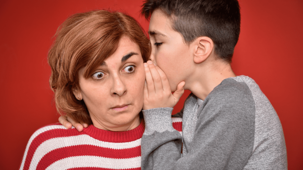 Young boy whispering something to his shocked mother.