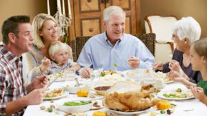 table filled with different family dishes for Thanksgiving