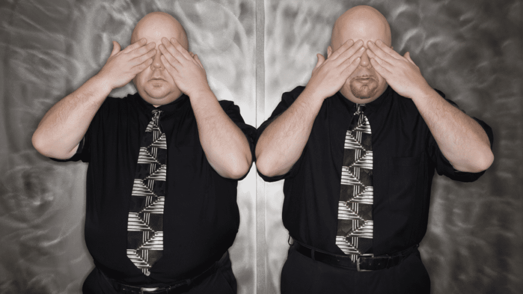 adult male twins dressing in black with geometric ties holding their hands over their eyes
