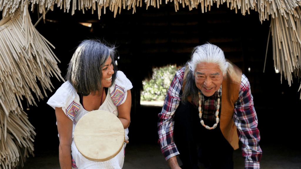 woman holding a drum and smiling at older man