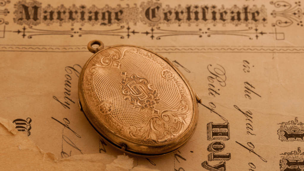 Engraved locket with marriage certificate in background. 