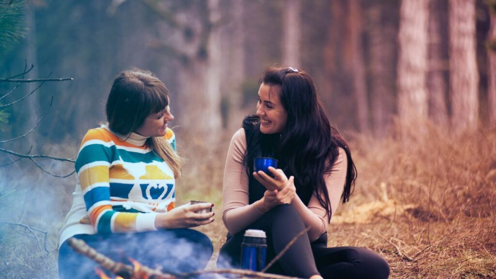 Women talking intently by fire.