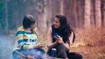 Women talking intently by fire.