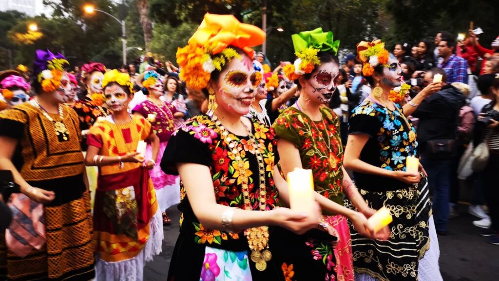 Day of the Dead celebration with participants in colorful costumes and makeup. 
