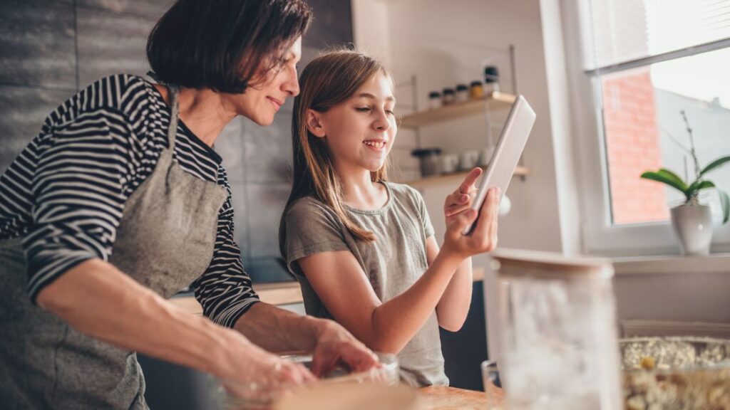 Grandmother and grandaughter cooking family recipe together.