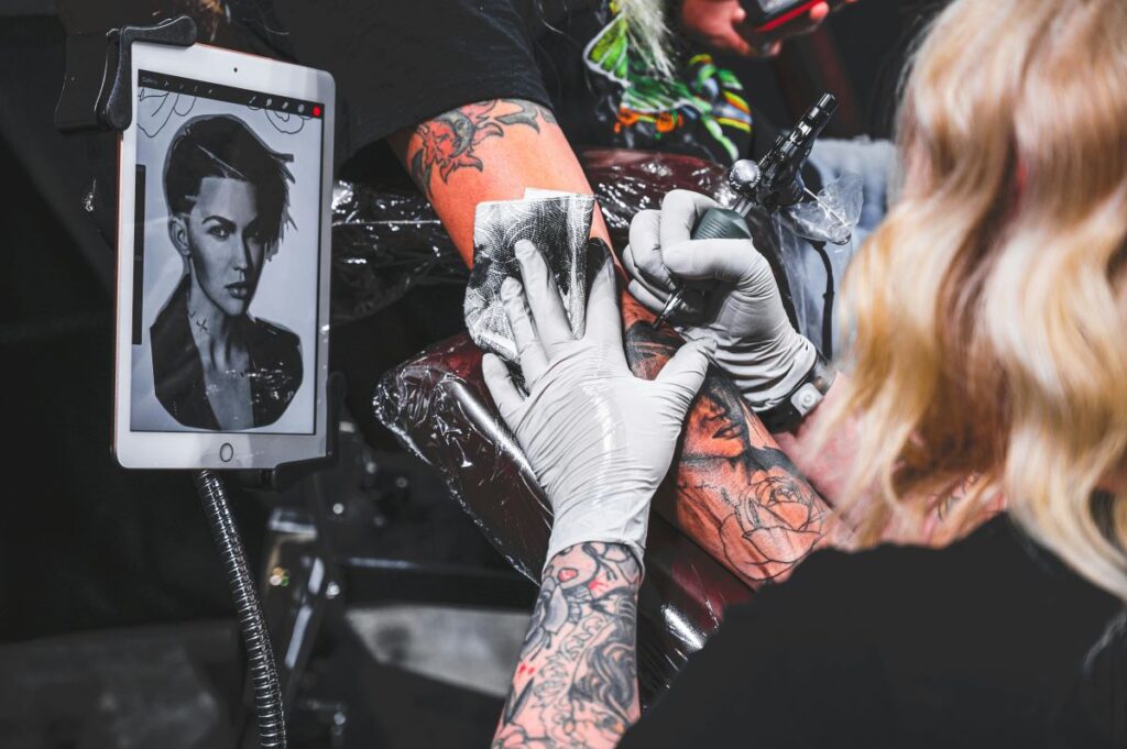 tattoo artist creating a portrait tattoo from a photograph