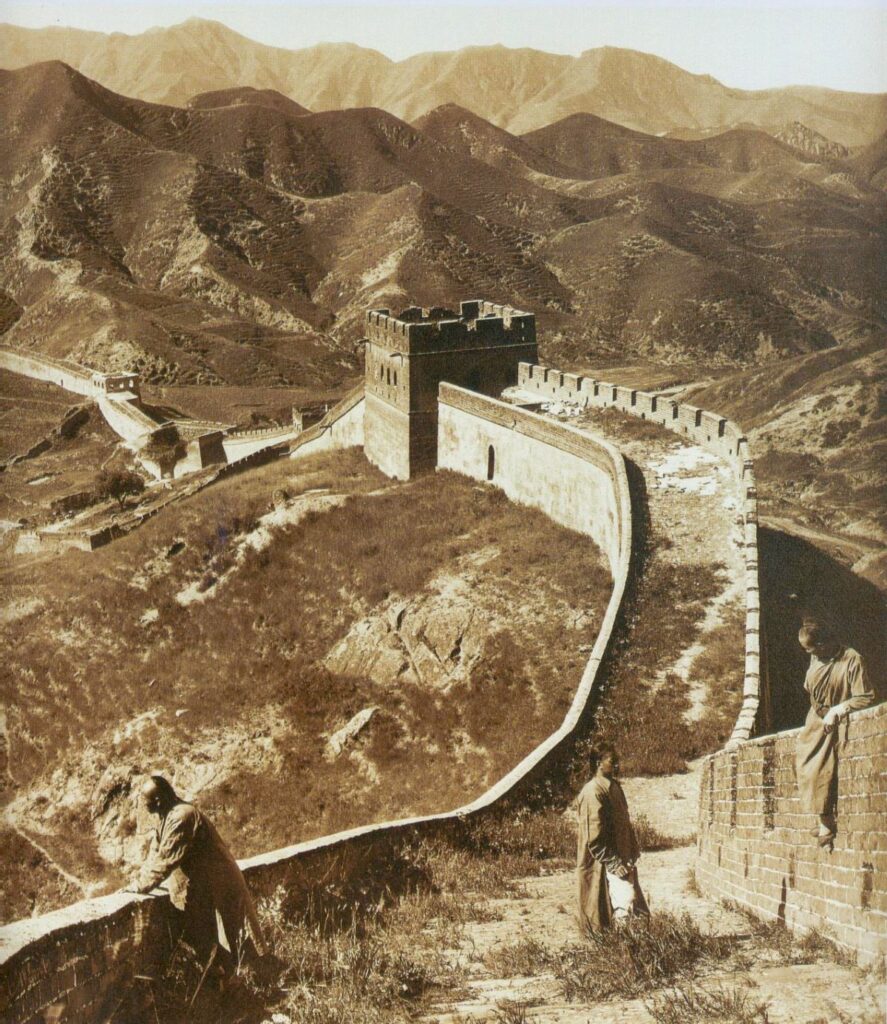 vintage photograph of the Great Wall of China with people walking and sitting on the wall