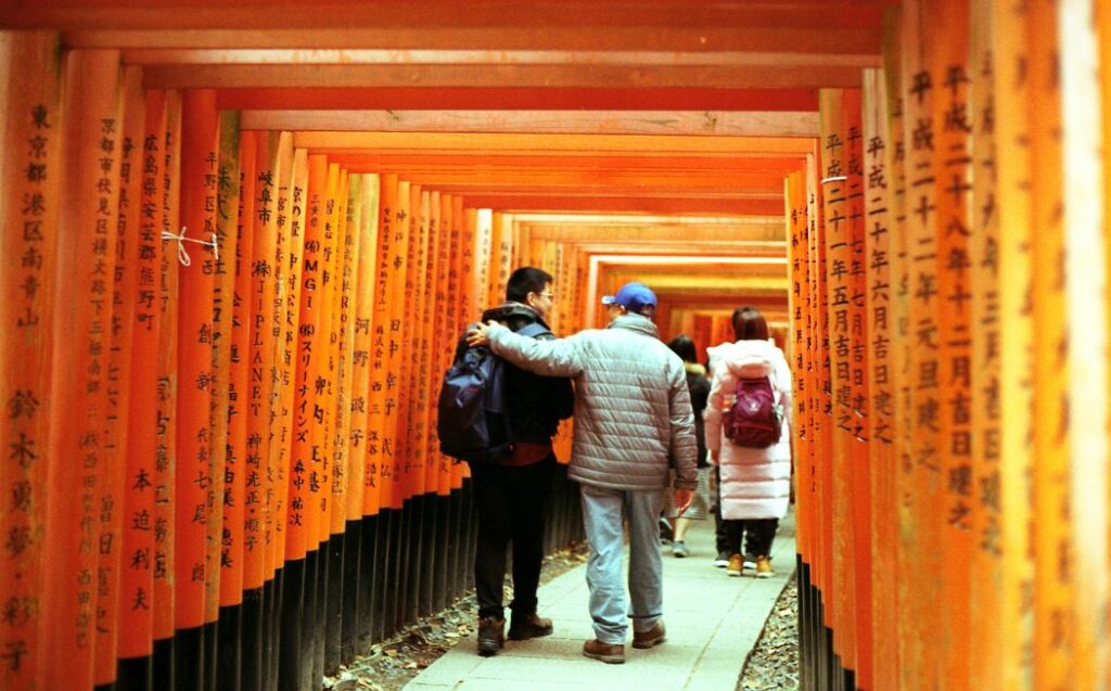 Visitors walking through the Fushimi Inari Shrine 