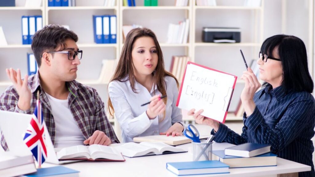 older woman holding up a tablet with words. Younger woman pointing and young man expressing confusion